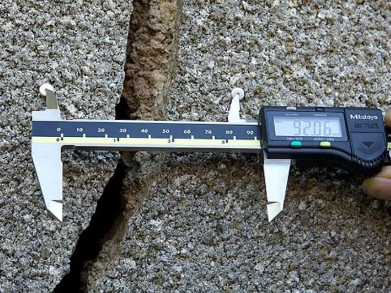 Digital gauge reading the distance between Demec studs either side of a crack