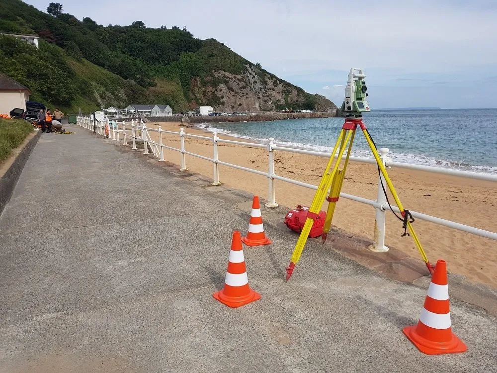 THS Concepts total station set up on a beach promenade in Jersey during a topographical survey
