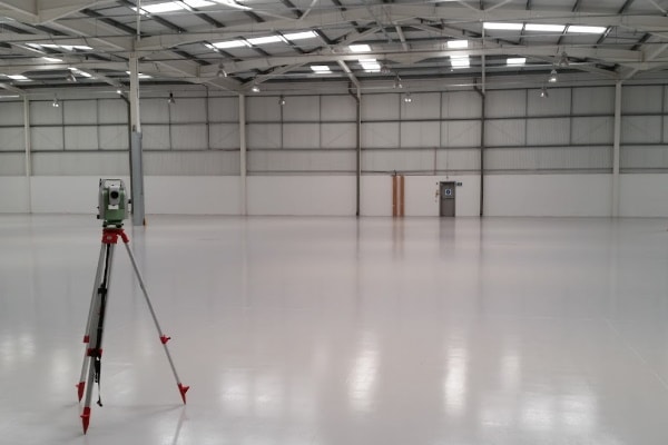 Measured survey with a total station in an empty warehouse